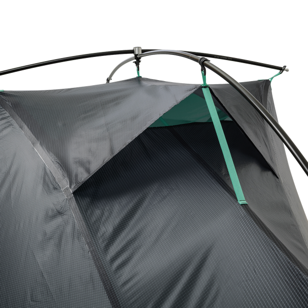Close-up of the Big Agnes Canada Pitchpine VST 1.5 ultralight tent in dark gray Hyperbead fabric, showing a partially open vent with green trim and black poles, displayed on a white background.