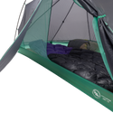 A close-up inside the Big Agnes Canada Pitchpine VST 1.5 shows sleeping bags and pads side by side on the floor, with mesh walls and an open door revealing its green and gray ultralight interior setup.