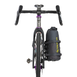 Bicycle with a black Tiger Wall UL Bikepack attached to the back on a white background