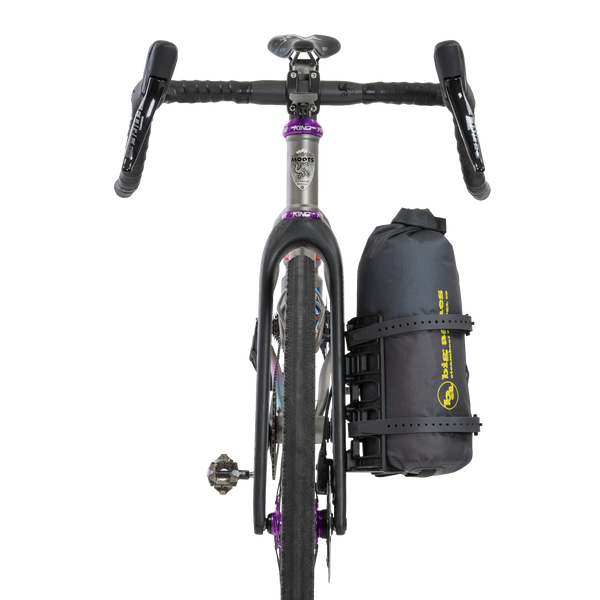 Bicycle with a black Tiger Wall UL Bikepack attached to the back on a white background